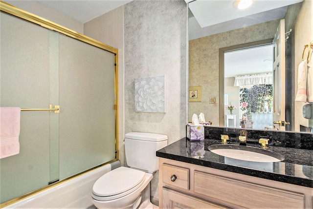 full bathroom featuring combined bath / shower with glass door, vanity, and toilet