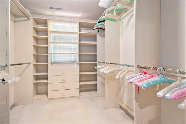 walk in closet featuring light colored carpet