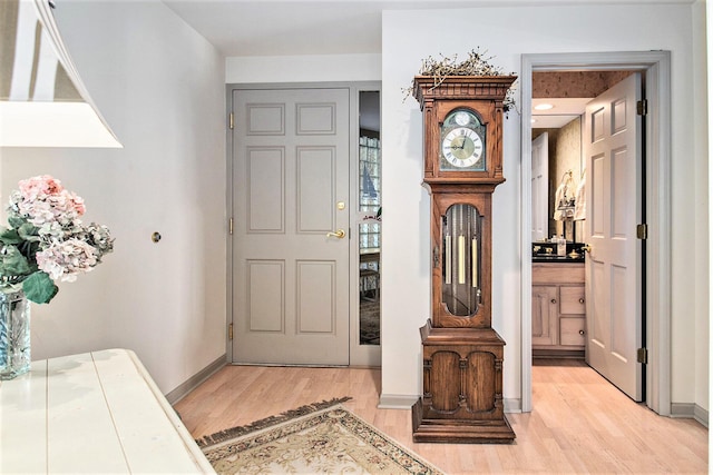 foyer entrance with light wood-style floors and baseboards