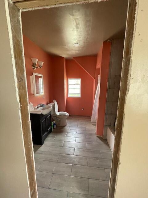 bathroom with tile patterned flooring, vaulted ceiling, and vanity