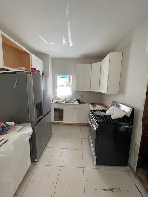 kitchen with stainless steel fridge with ice dispenser, gas stove, and white cabinets