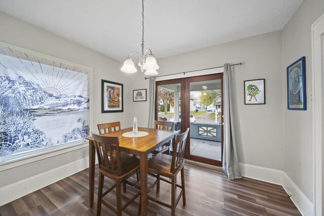 dining room featuring dark wood-type flooring, french doors, and an inviting chandelier