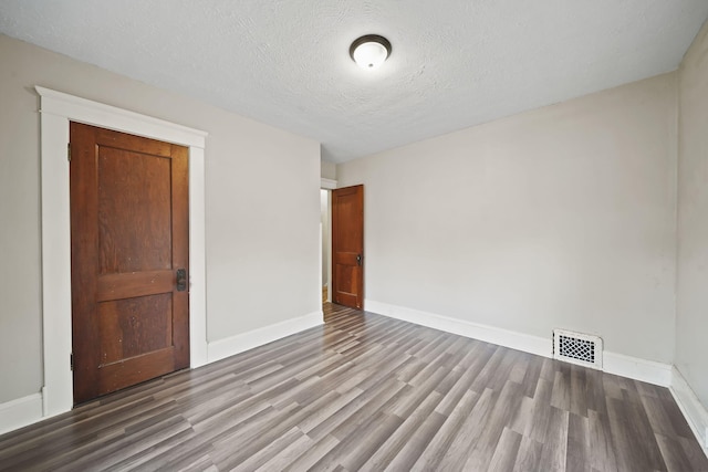 unfurnished bedroom featuring a closet, wood-type flooring, and a textured ceiling