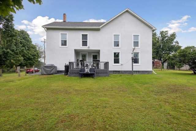 back of house featuring a wooden deck and a yard