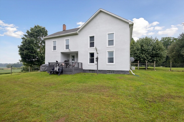 back of property featuring a lawn and a deck