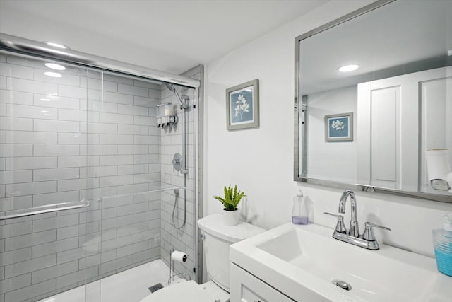 bathroom with toilet, an enclosed shower, and vanity