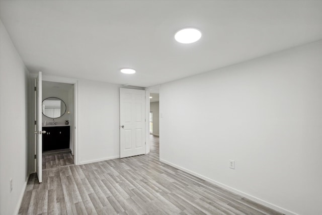 unfurnished bedroom featuring sink and light hardwood / wood-style floors