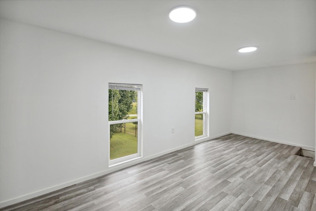 unfurnished room featuring a wealth of natural light and hardwood / wood-style flooring