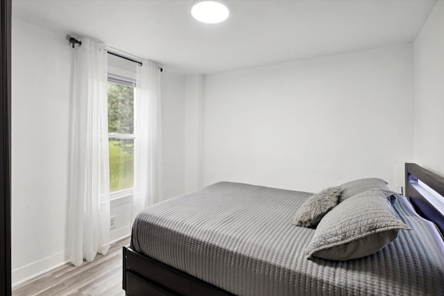 bedroom featuring multiple windows and light wood-type flooring