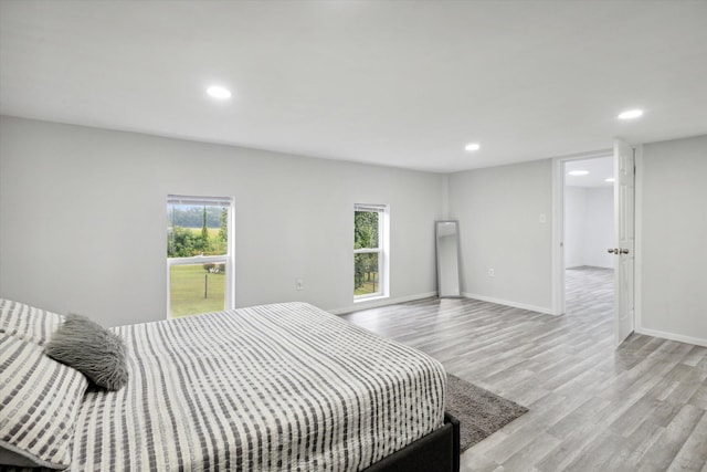 bedroom with light hardwood / wood-style flooring and multiple windows