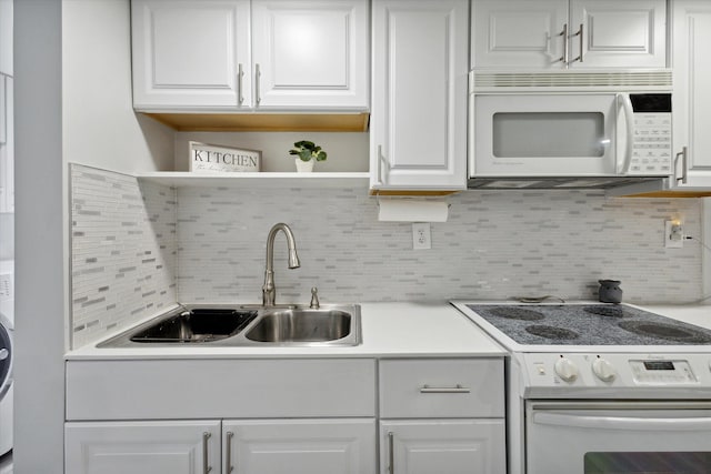 kitchen with sink, white appliances, decorative backsplash, and white cabinetry