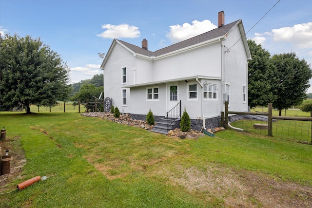 rear view of property with a lawn