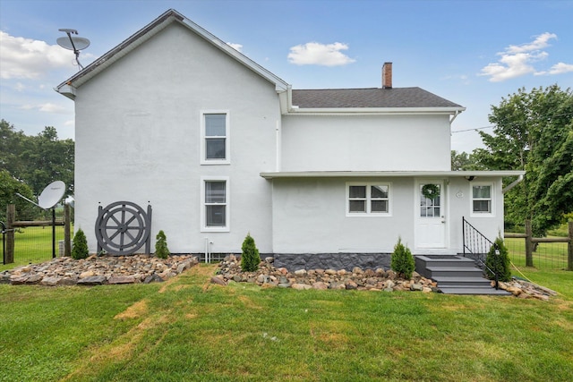 rear view of property with a yard