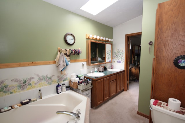 bathroom featuring a bathtub, toilet, vaulted ceiling, and vanity