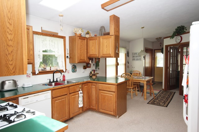 kitchen with pendant lighting, light carpet, sink, and kitchen peninsula