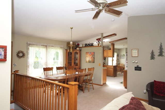 carpeted dining space with lofted ceiling and ceiling fan with notable chandelier