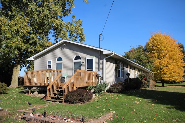 view of front of home featuring a front yard and a wooden deck