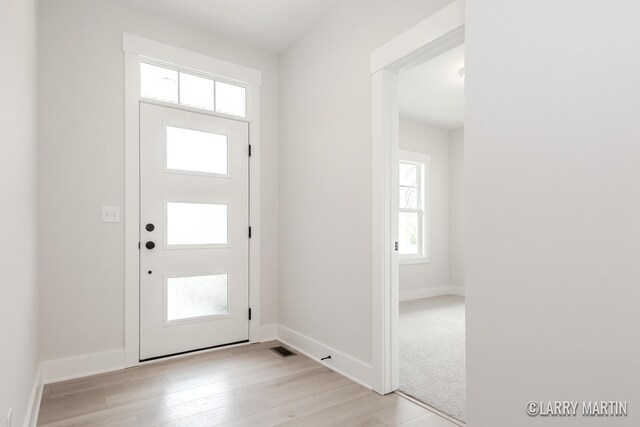 entrance foyer with visible vents, baseboards, and light wood-style floors