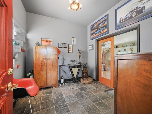 misc room featuring an inviting chandelier and dark tile patterned floors