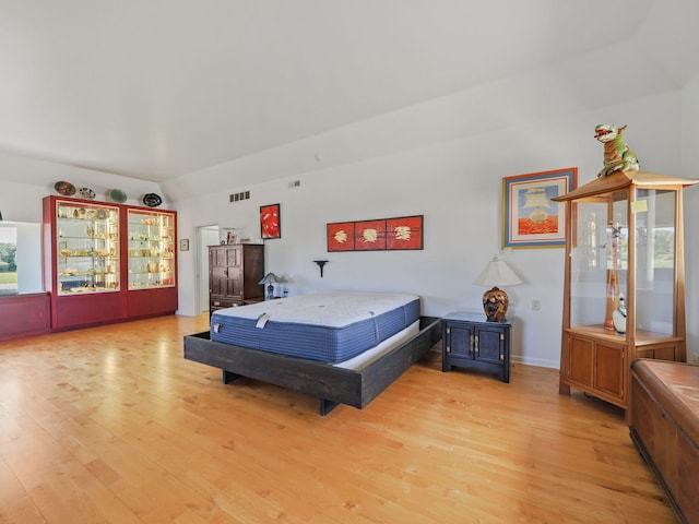 bedroom with light hardwood / wood-style flooring and lofted ceiling