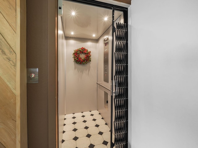 interior details featuring tile patterned flooring and elevator