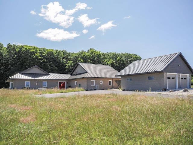 view of front of house with a garage and an outbuilding