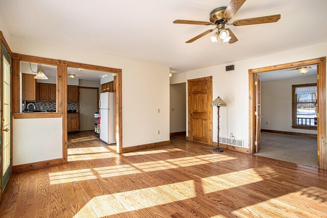 spare room featuring light hardwood / wood-style flooring, ceiling fan, and sink