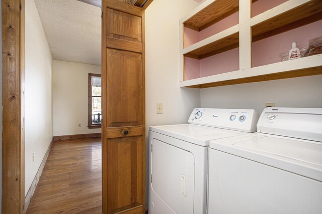 laundry area featuring separate washer and dryer, hardwood / wood-style floors, and a textured ceiling