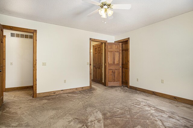 unfurnished bedroom with carpet flooring, ceiling fan, and a textured ceiling