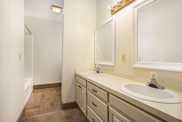 bathroom featuring vanity, a textured ceiling, and bathtub / shower combination