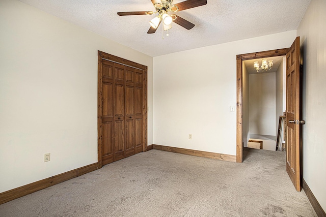 unfurnished bedroom featuring ceiling fan with notable chandelier, a textured ceiling, and light carpet