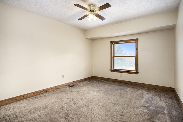 empty room featuring ceiling fan, carpet floors, and a textured ceiling