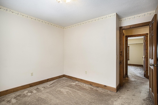 carpeted spare room featuring a textured ceiling