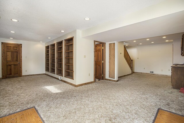 basement with carpet flooring and a textured ceiling