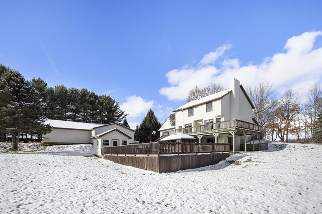 snow covered house with a deck