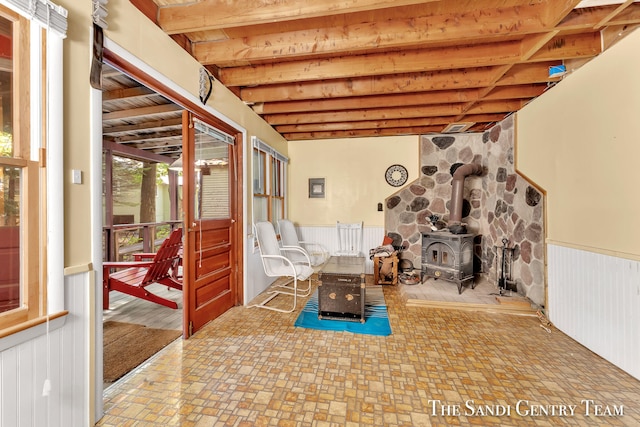 basement with a wood stove and tile patterned floors