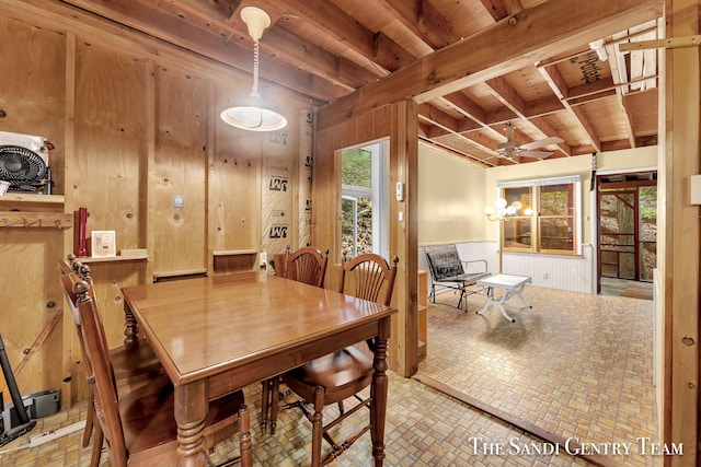 tiled dining area featuring wood walls, ceiling fan, wooden ceiling, and beamed ceiling