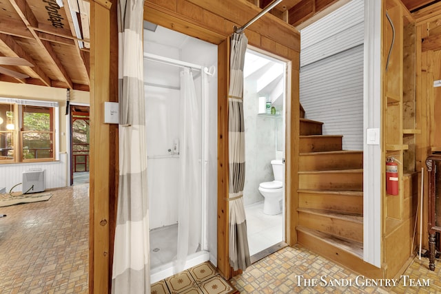 bathroom with a shower with shower curtain, toilet, and tile patterned floors