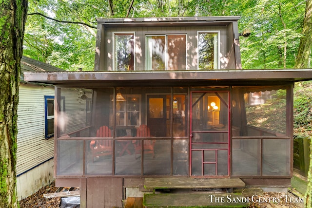 rear view of house featuring a sunroom