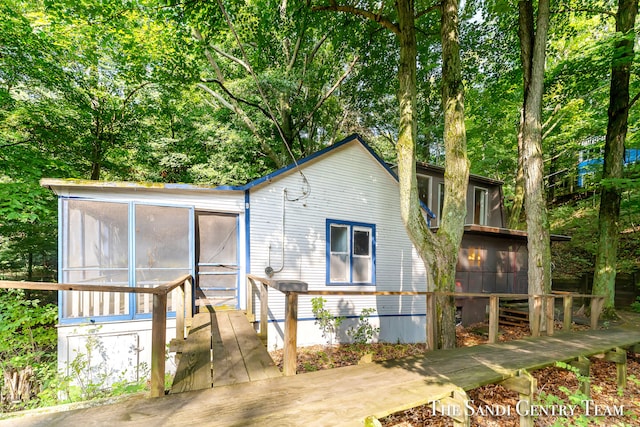 rear view of property featuring a sunroom