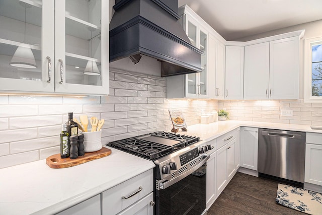 kitchen with stainless steel appliances, white cabinetry, backsplash, custom exhaust hood, and dark wood finished floors