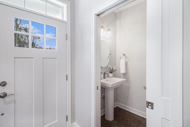 bathroom with a sink, baseboards, and wood finished floors