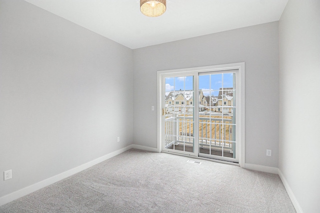 carpeted spare room featuring visible vents and baseboards