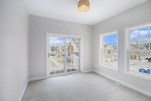 carpeted spare room with baseboards and visible vents