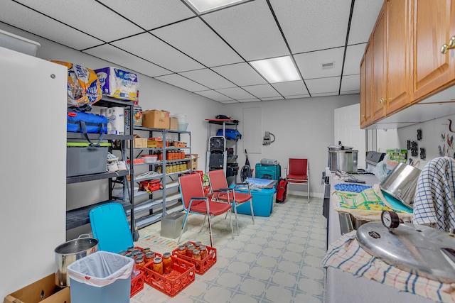 interior space with light tile patterned floors and a drop ceiling