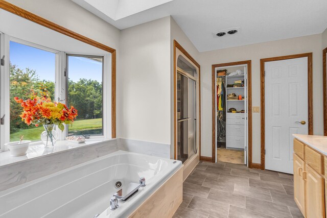 bathroom with shower with separate bathtub, vanity, and tile patterned floors