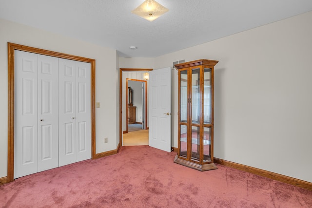 unfurnished bedroom featuring carpet, a closet, and a textured ceiling