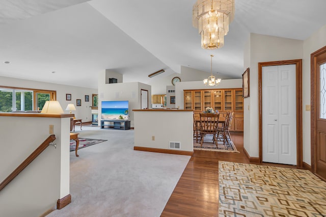 carpeted entryway with high vaulted ceiling and a chandelier