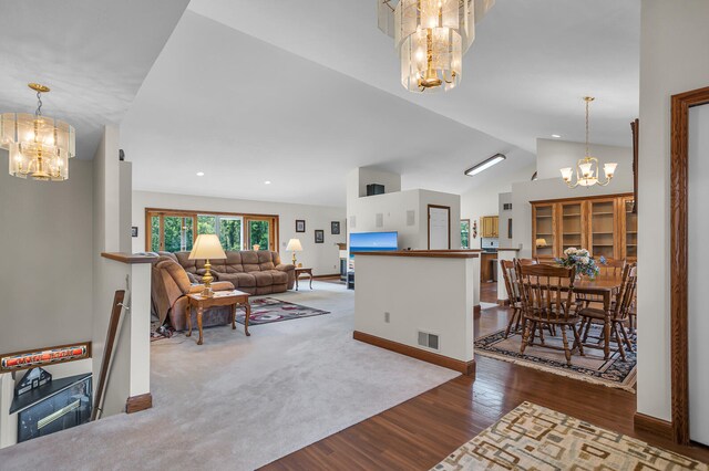 carpeted living room featuring a notable chandelier and lofted ceiling