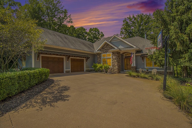 craftsman inspired home with driveway, stone siding, a shingled roof, and a garage